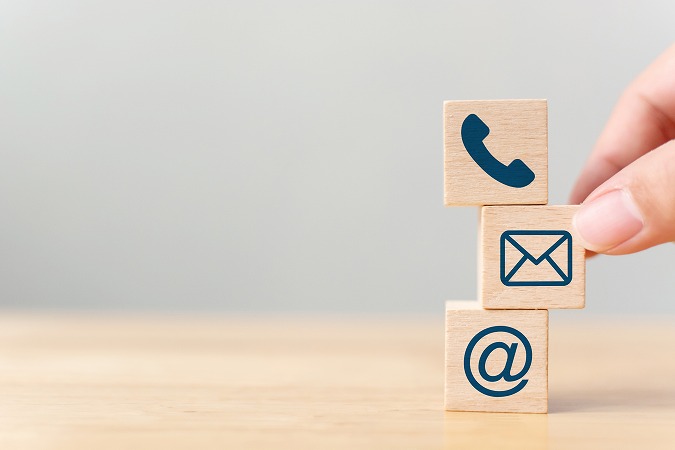 電話とメールのマークがかかれた木のブロック